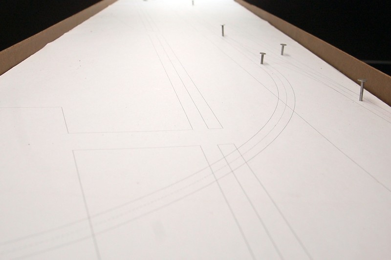 After developing the trackplan in XTRKCAD, I printed it out in 1:1 scale using a plotter printer on long rolls of paper to avoid having to stitch it together over multiple sheets.  Using a dedicated CAD/CAM program ensures that everything will fit correctly and allows you to better visualize relationships between objects, including roads and structures.